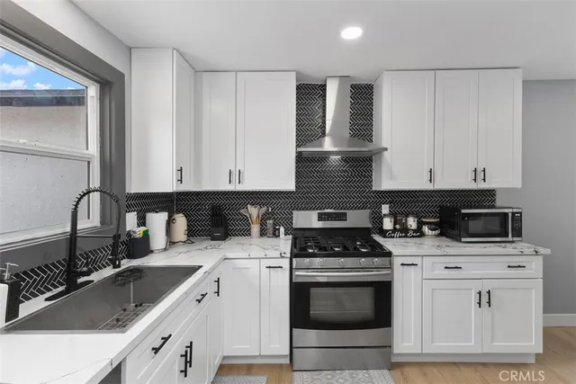a kitchen with granite countertop a sink stove and cabinets