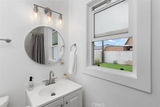 a bathroom with a sink mirror and window