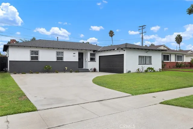 a front view of a house with a garden and yard