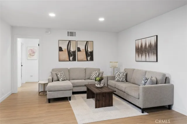 a living room with furniture and a wooden floor