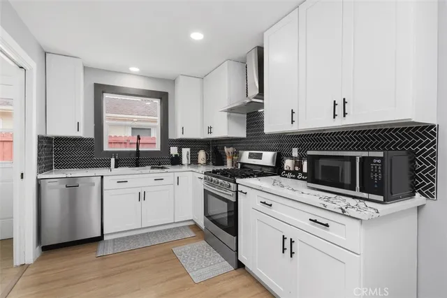 a kitchen with stainless steel appliances granite countertop a stove a sink and a microwave