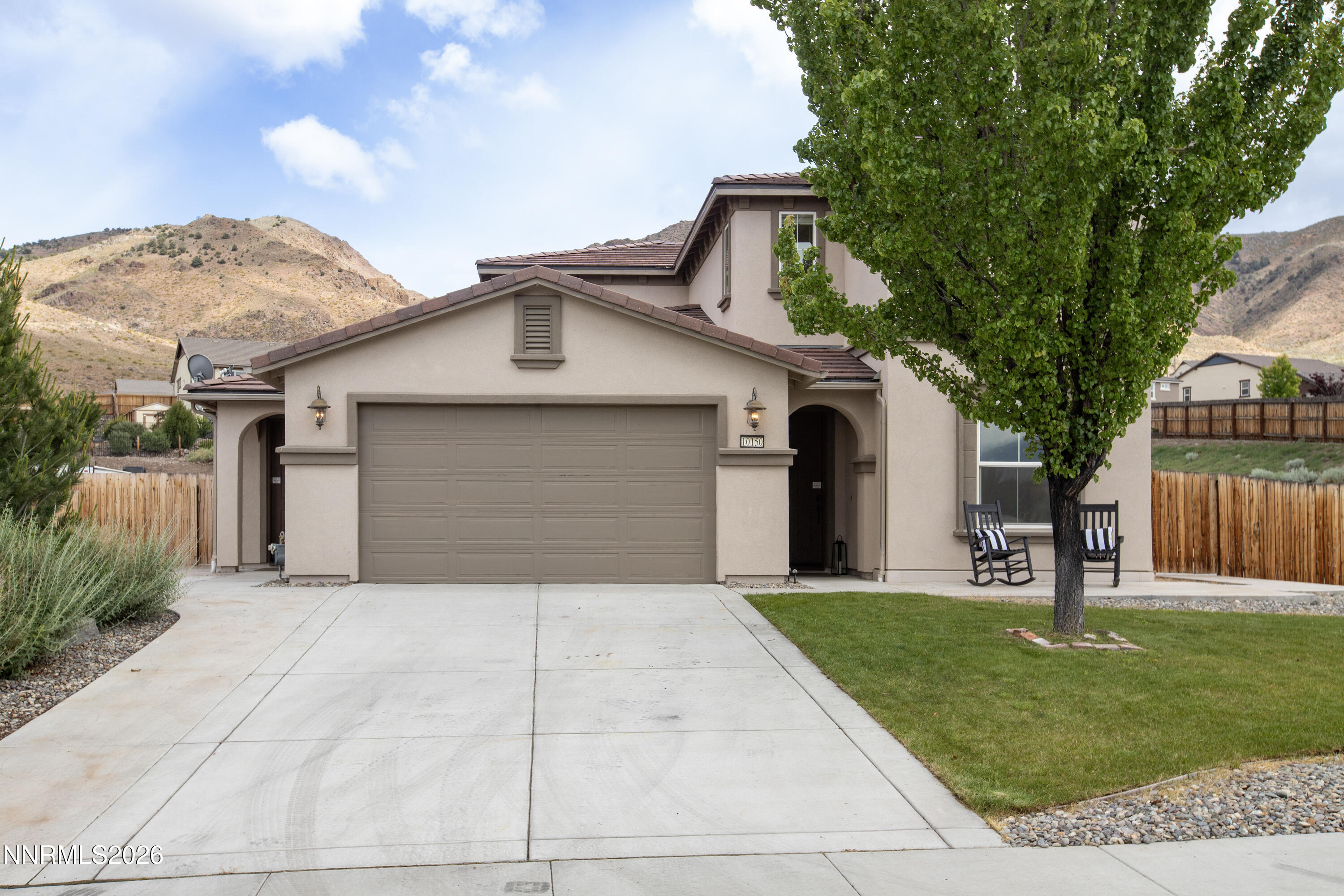 10150 Barrel Racer Drive Reno, NV 89521 - Photo 42 of 64 a front view of a house with a garden and trees