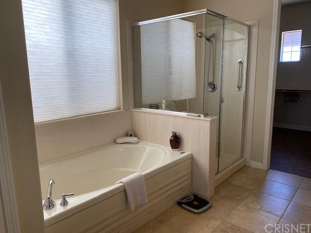 a bedroom with a bed and a flat tv screen on a dresser