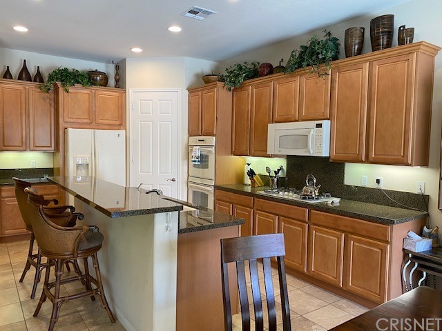 80278 Camino San Mateo Indio, CA 92203 - Photo 10 of 63 a kitchen with stainless steel appliances granite countertop a stove top oven a sink and cabinets