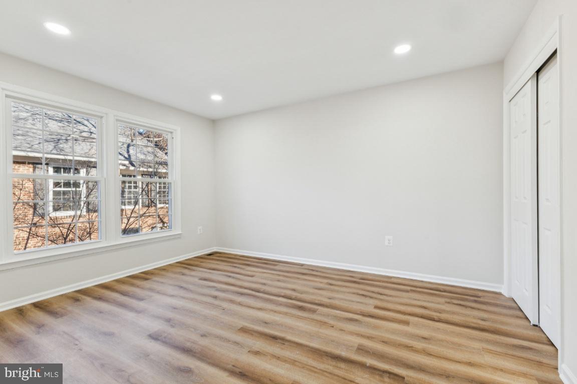 2452 South Walter Reed Drive, Unit 3 Arlington, VA 22206 - Photo 12 of 32 a view of an empty room with wooden floor and a window