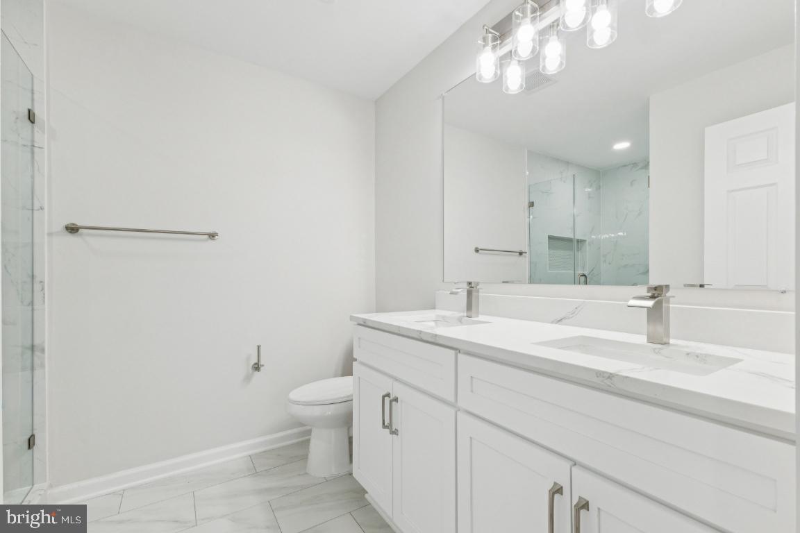 2452 South Walter Reed Drive, Unit 3 Arlington, VA 22206 - Photo 13 of 32 a bathroom with a sink a toilet and a mirror