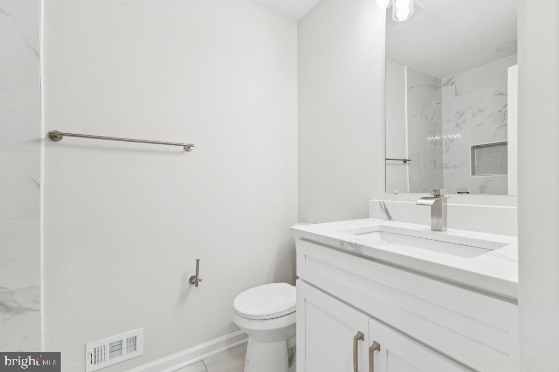2452 South Walter Reed Drive, Unit 3 Arlington, VA 22206 - Photo 17 of 32 a bathroom with a sink toilet and vanity