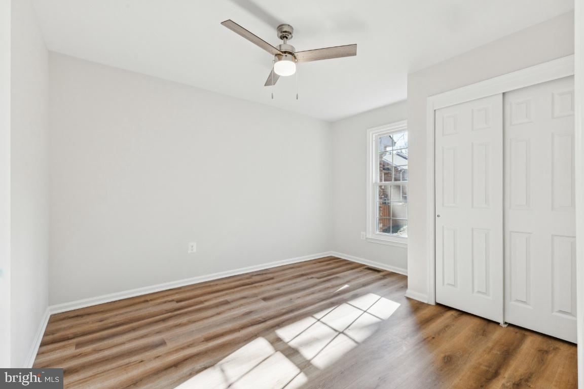 2452 South Walter Reed Drive, Unit 3 Arlington, VA 22206 - Photo 18 of 32 an empty room with wooden floor ceiling fan and windows