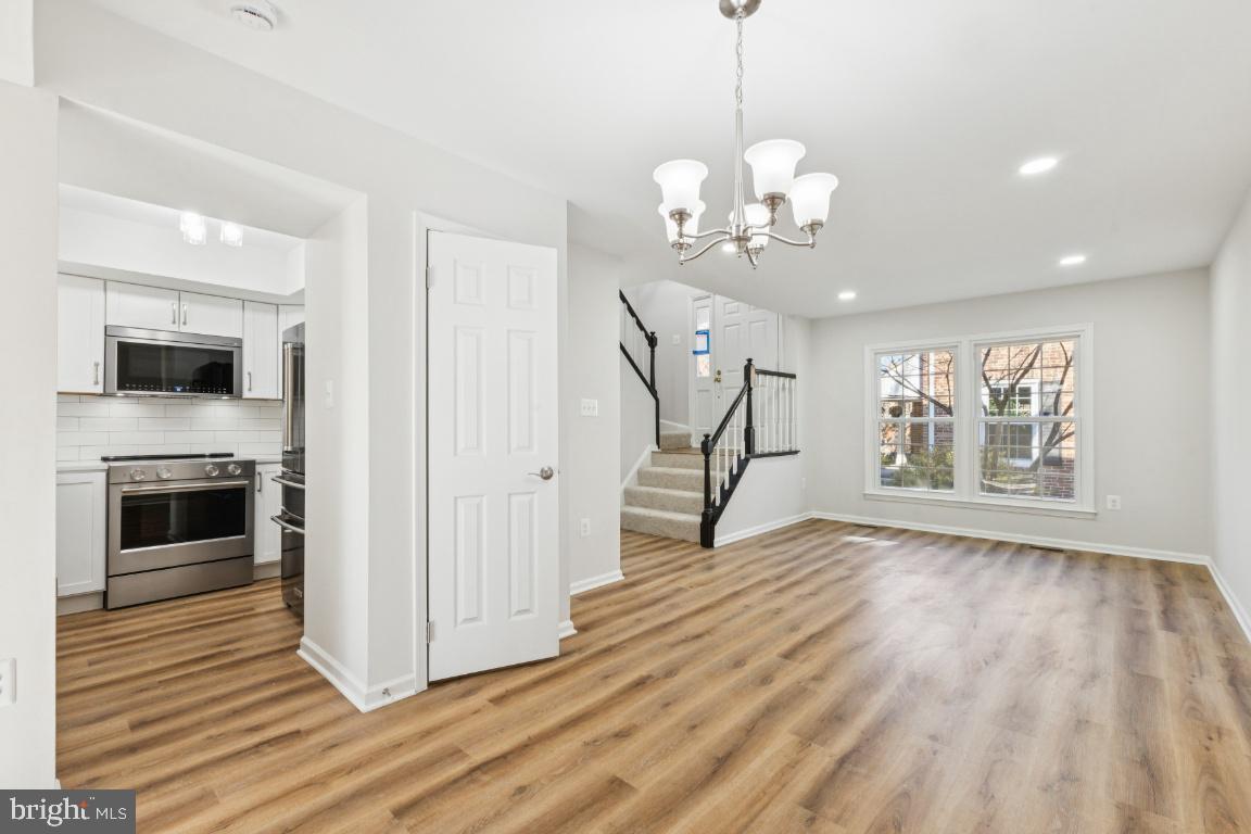 2452 South Walter Reed Drive, Unit 3 Arlington, VA 22206 - Photo 4 of 32 a view of a livingroom with wooden floor a ceiling fan and windows