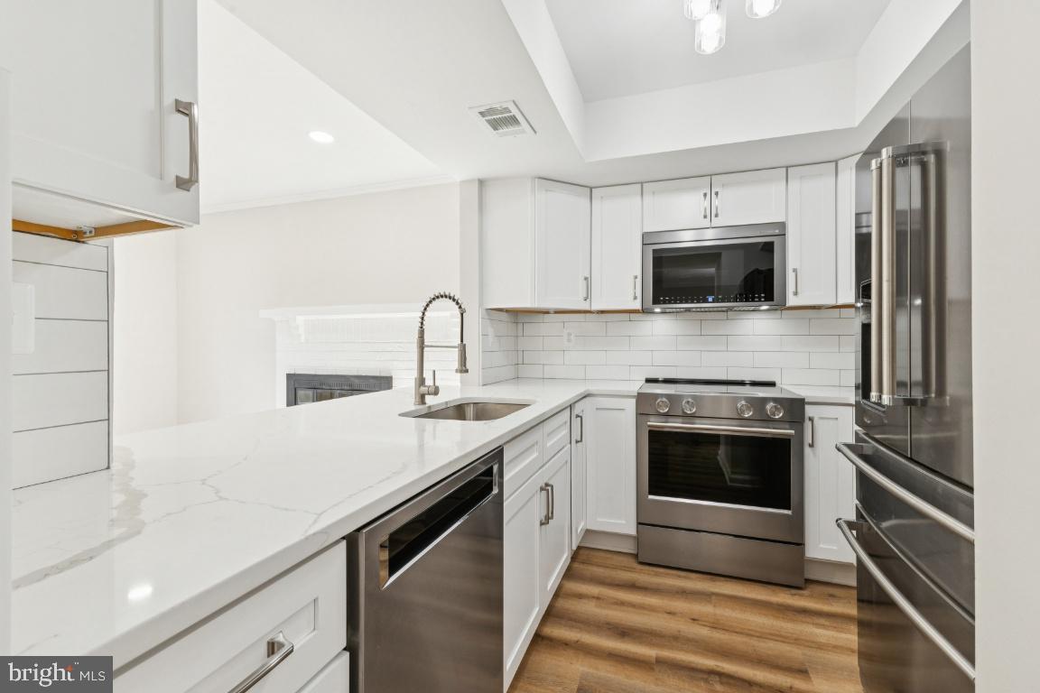 2452 South Walter Reed Drive, Unit 3 Arlington, VA 22206 - Photo 5 of 32 a kitchen with a sink stove and microwave