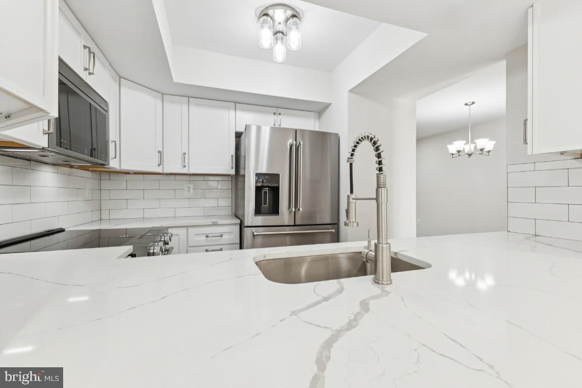 2452 South Walter Reed Drive, Unit 3 Arlington, VA 22206 - Photo 6 of 32 a kitchen with stainless steel appliances granite countertop a sink and a refrigerator