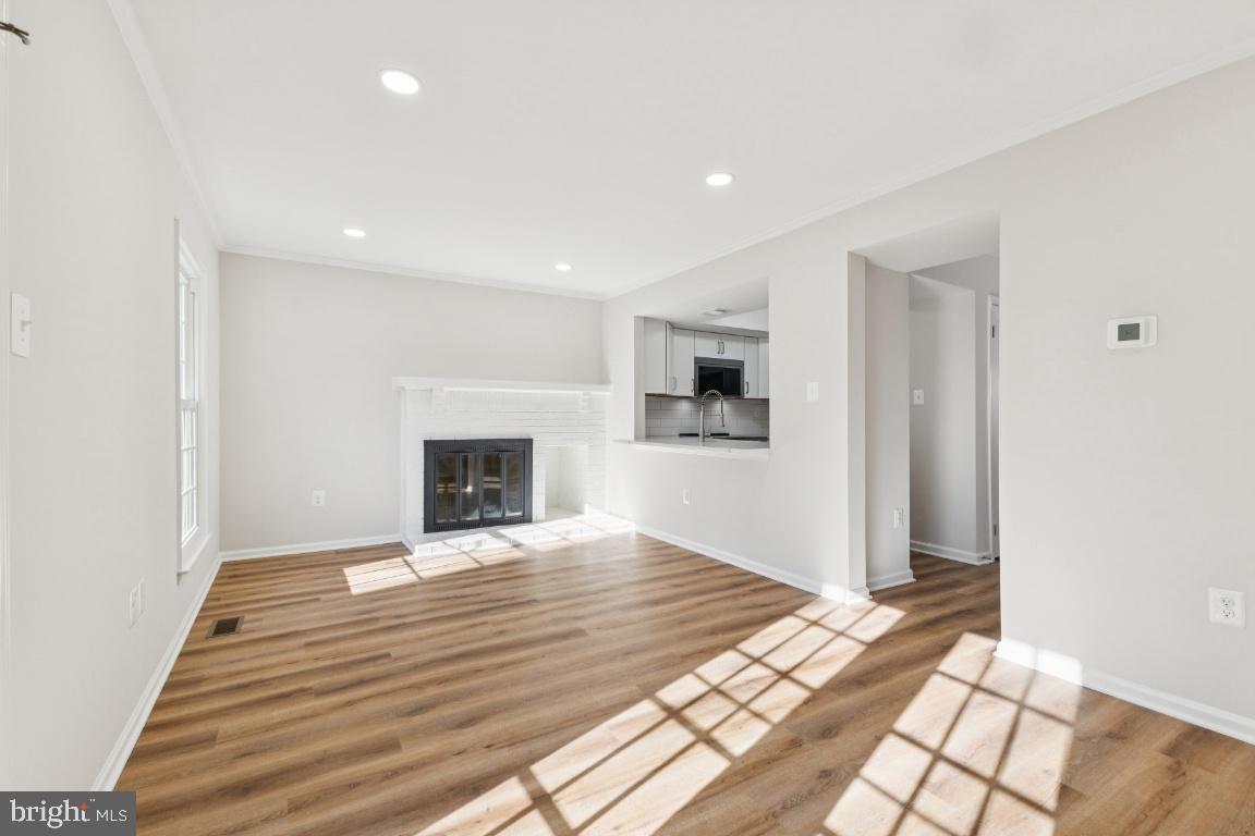 2452 South Walter Reed Drive, Unit 3 Arlington, VA 22206 - Photo 7 of 32 a view of empty room with wooden floor and fireplace