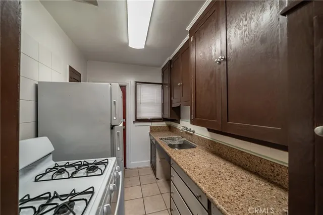 a kitchen with a refrigerator and a stove top oven