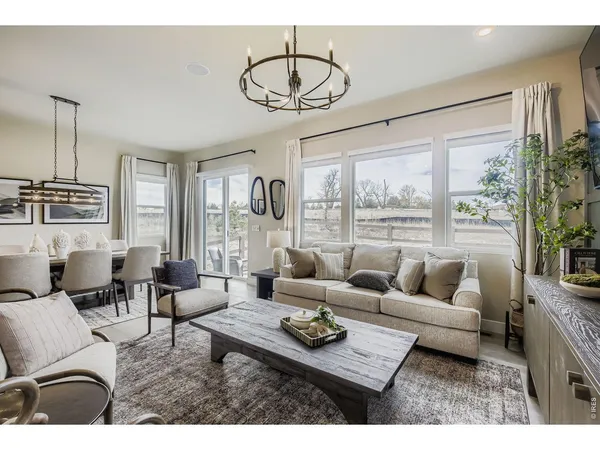 a living room with furniture a flat screen tv and a floor to ceiling window
