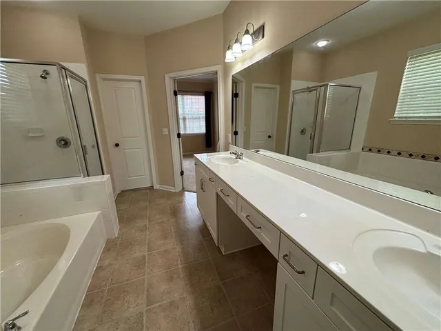 a bathroom with a tub sink and mirror