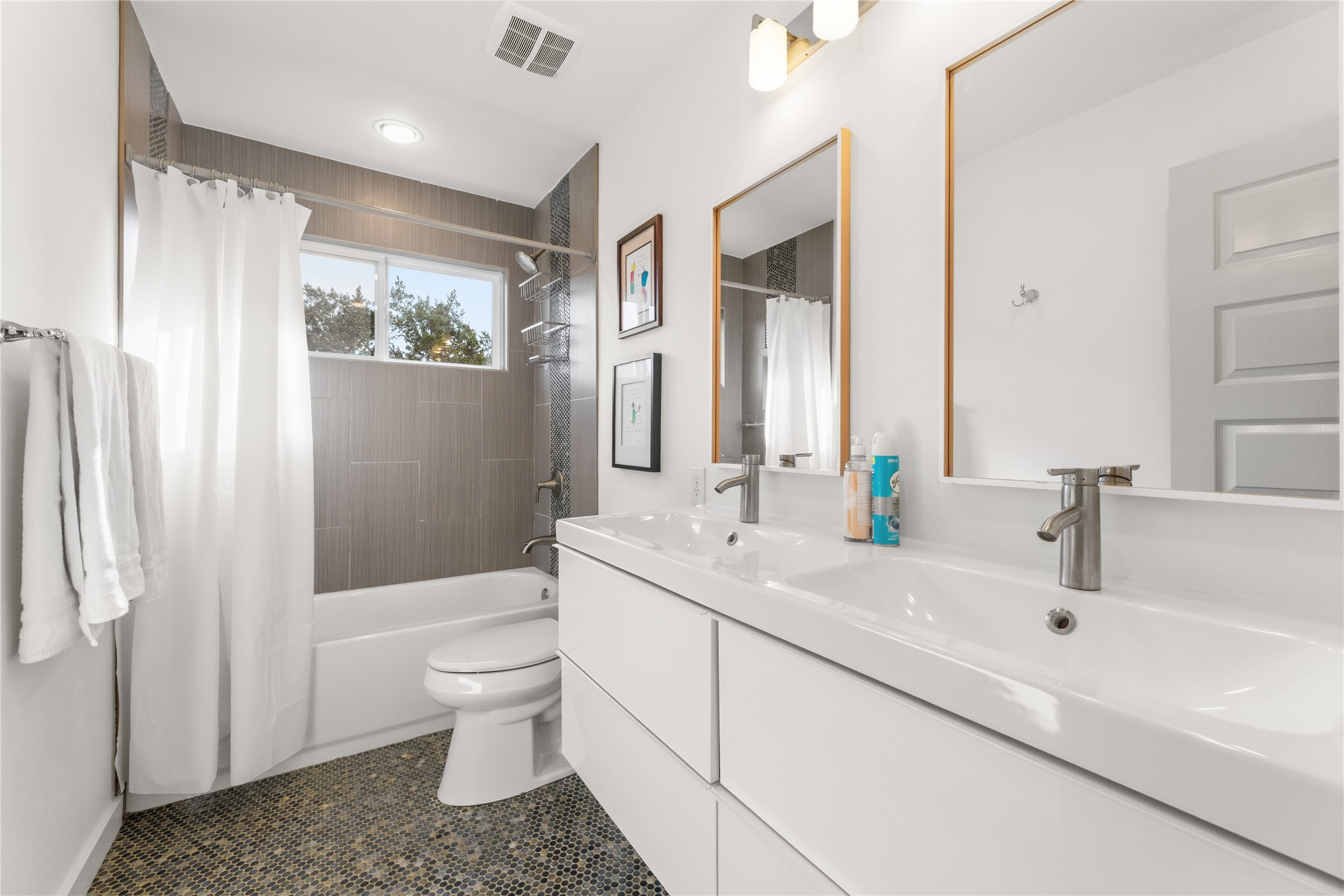 12901 Wire Road Leander, TX 78641 - Photo 17 of 40 A sleek double vanity and modern tiling elevate this clean bathroom space.
