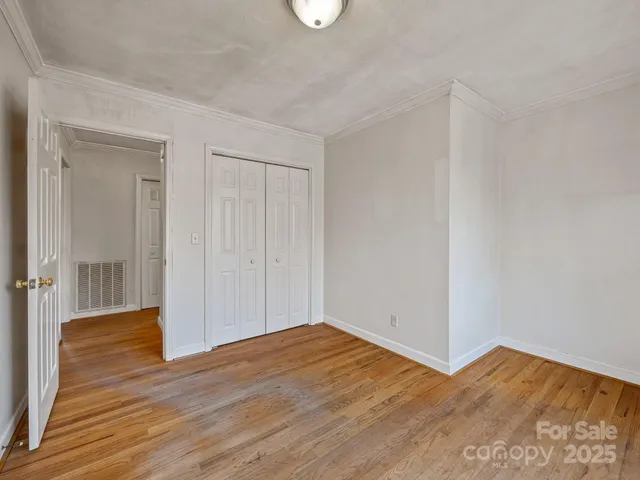a view of empty room with wooden floor