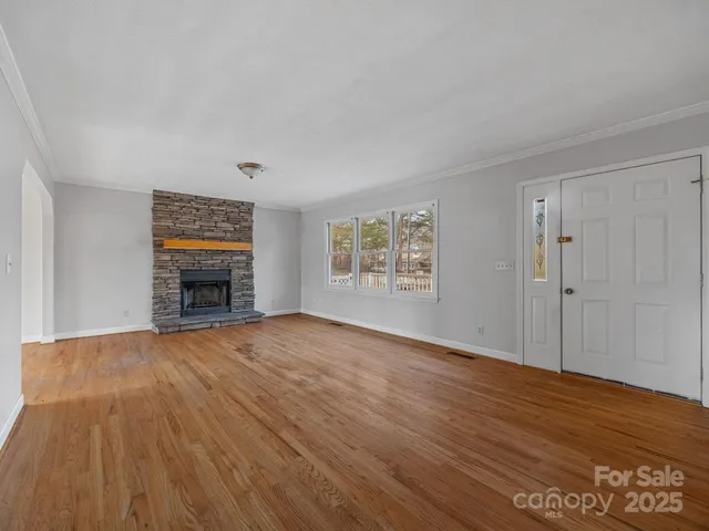 a view of empty room with wooden floor and fireplace