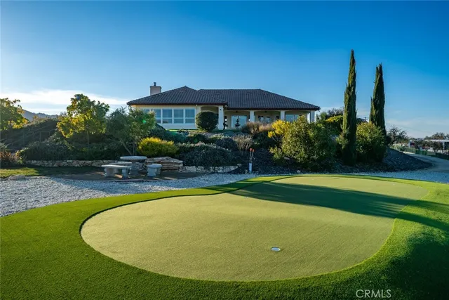 a view of pool with lawn chairs under an umbrella