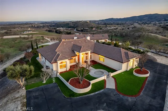 an aerial view of a house with garden space and a car parked on the road