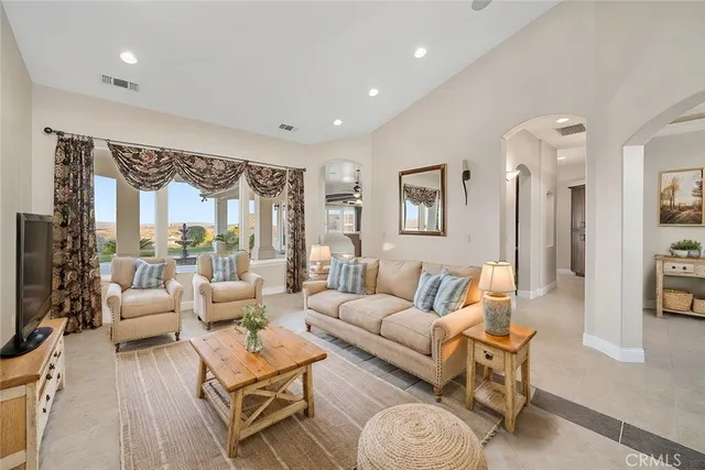 a living room with furniture wooden floor and a large window