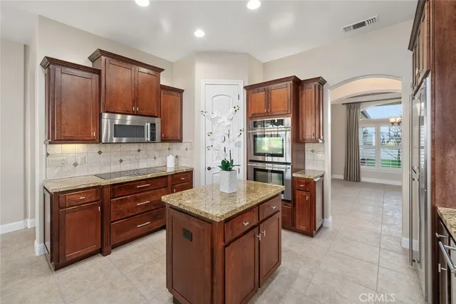 a kitchen with granite countertop a sink and a stove top oven