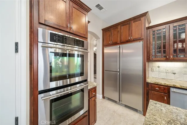 a kitchen with stainless steel appliances granite countertop a refrigerator and a stove top oven