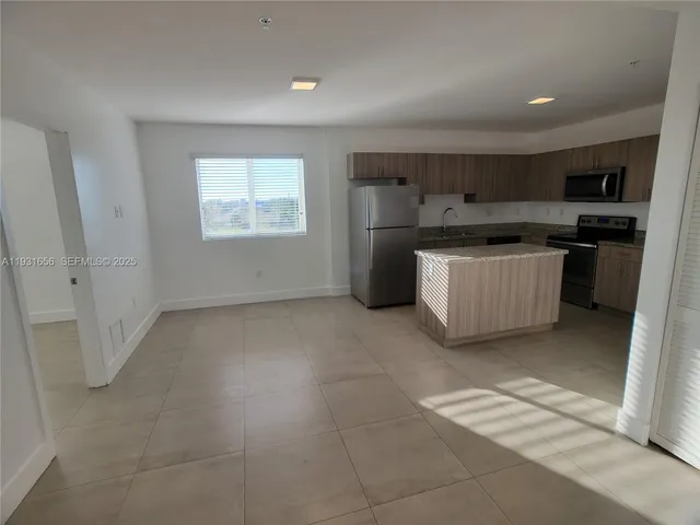 a kitchen with a refrigerator sink and wooden cabinets