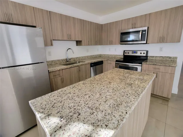 a kitchen with refrigerator and cabinets