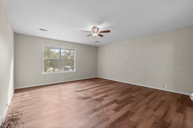 wooden floor in an empty room with a window