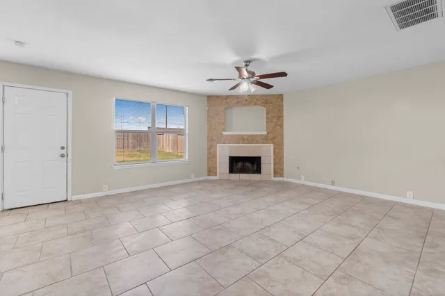 a view of empty room with cabinet and fireplace