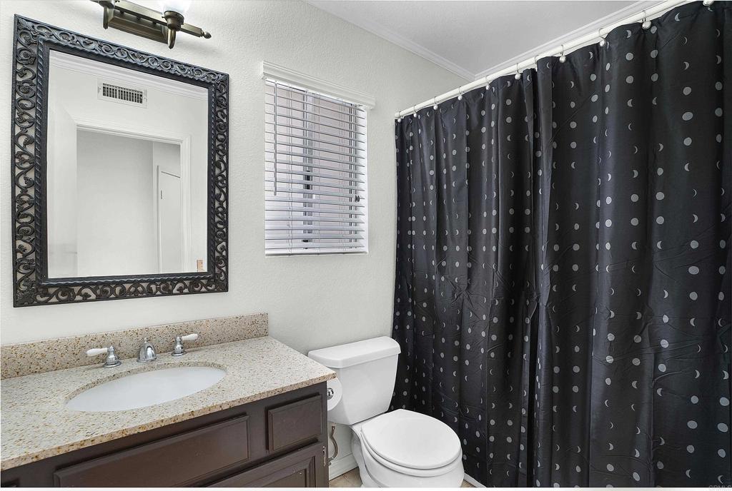 1826 Avenida Sevilla Oceanside, CA 92056 - Photo 30 of 34 a bathroom with a granite countertop sink mirror vanity and toilet
