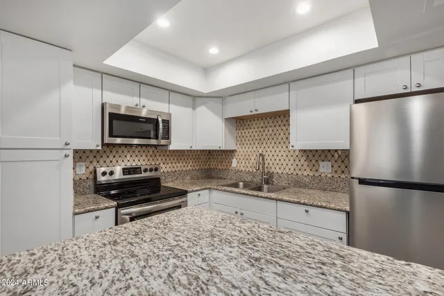 a kitchen with stainless steel appliances granite countertop a stove and a sink