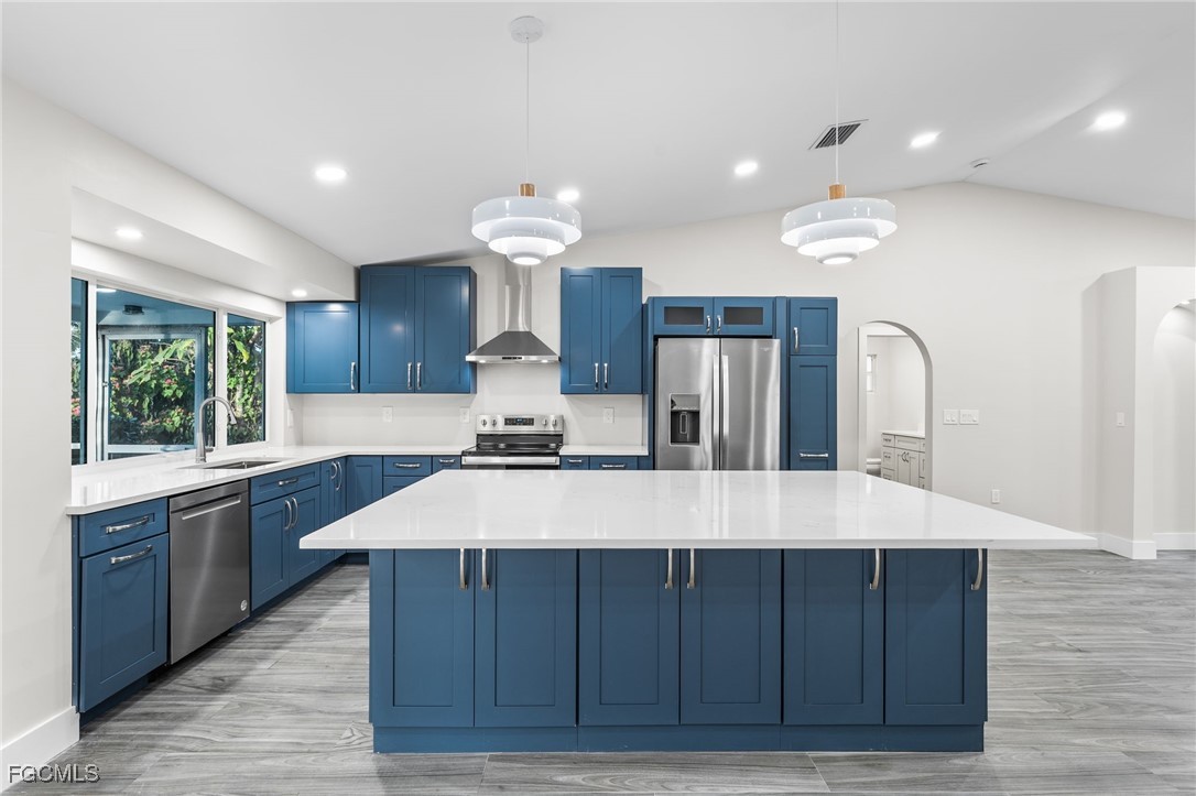 12860 Iona Road Fort Myers, FL 33908 - Photo 11 of 44 a large kitchen with wooden floors and wooden cabinets