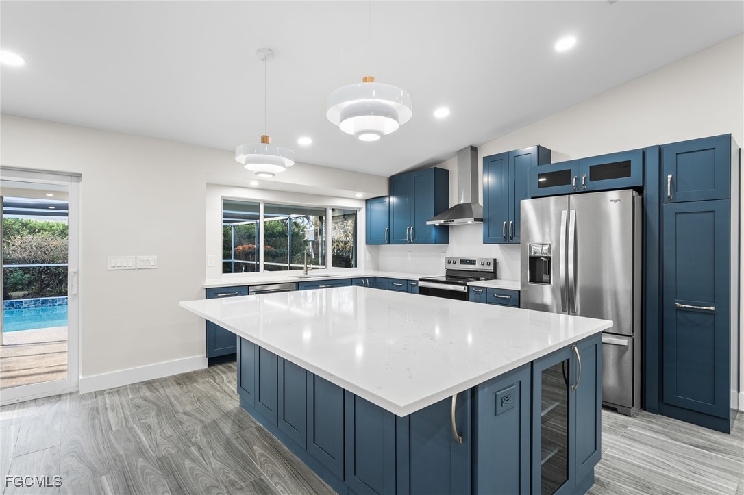 12860 Iona Road Fort Myers, FL 33908 - Photo 13 of 44 a large kitchen with kitchen island a large counter top and stainless steel appliances
