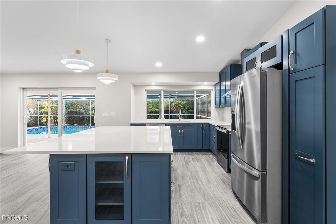 12860 Iona Road Fort Myers, FL 33908 - Photo 14 of 44 a kitchen with stainless steel appliances a refrigerator and a wooden floor