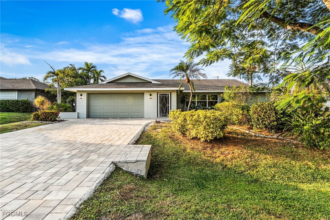 12860 Iona Road Fort Myers, FL 33908 - Photo 2 of 44 a front view of a house with a yard garage and outdoor seating