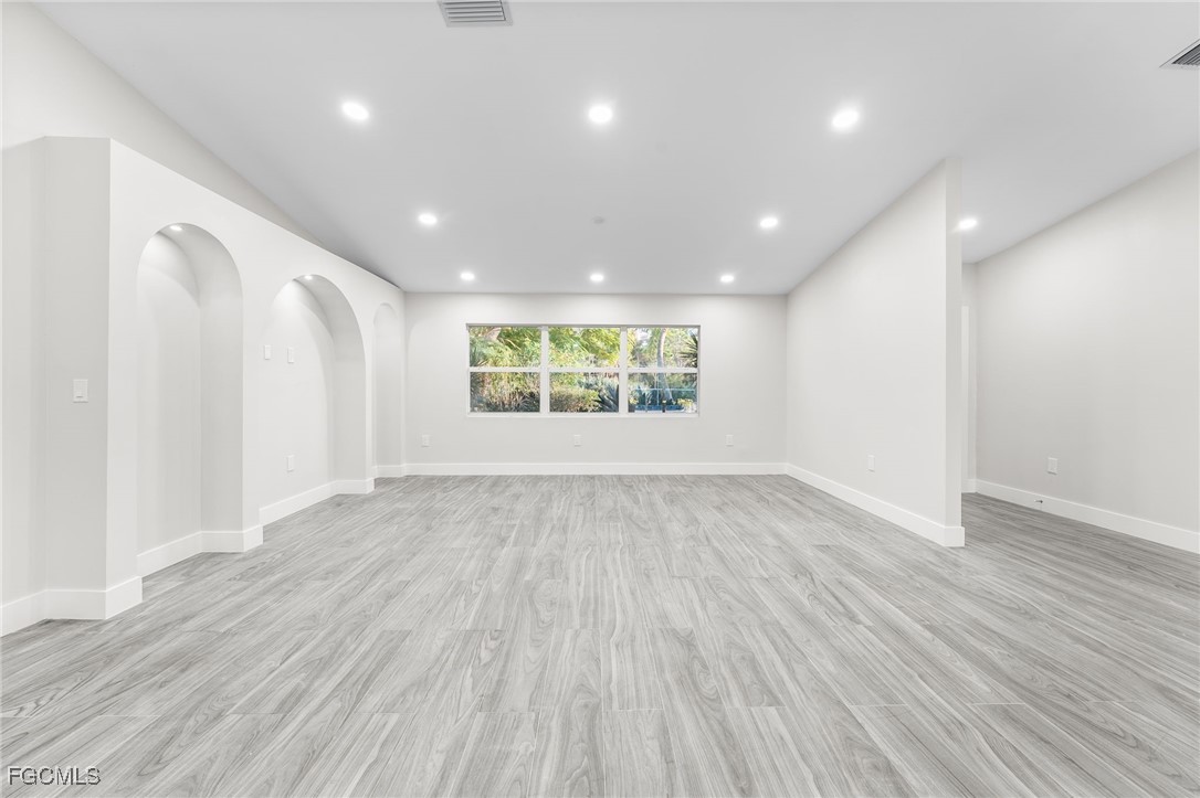 12860 Iona Road Fort Myers, FL 33908 - Photo 22 of 44 an empty room with wooden floor and windows