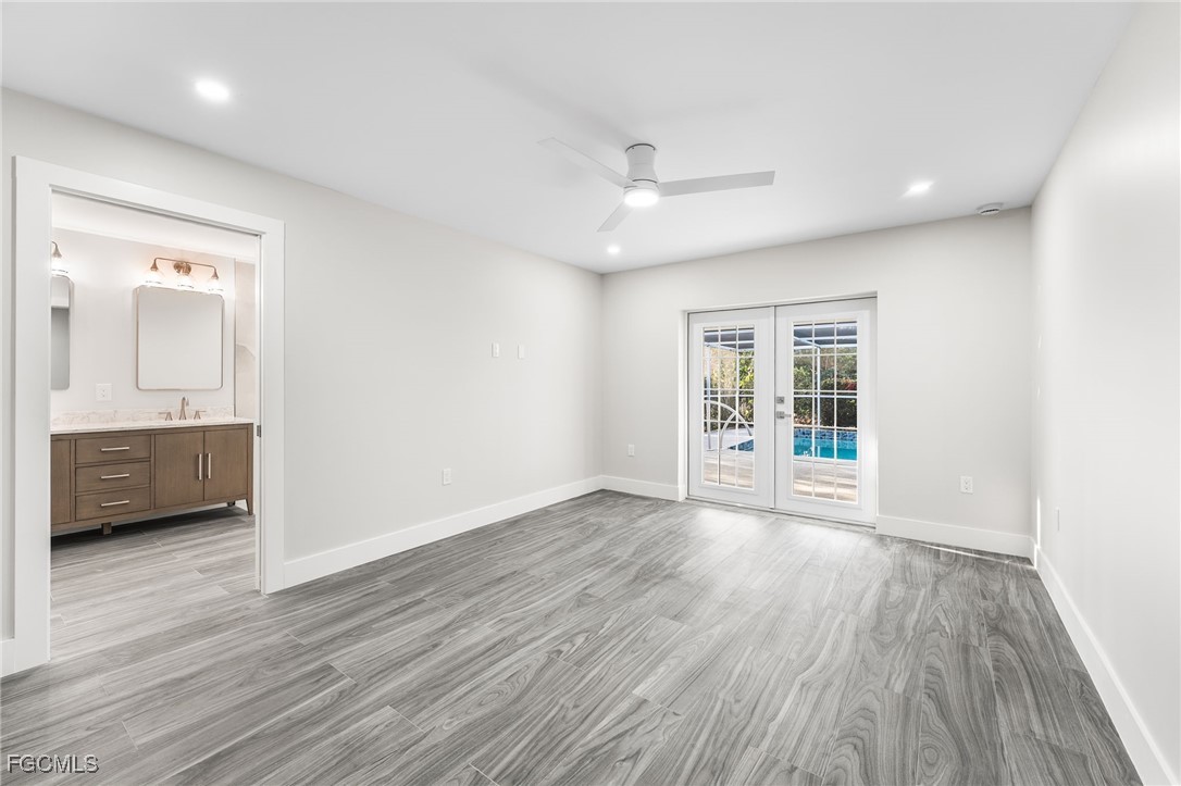 12860 Iona Road Fort Myers, FL 33908 - Photo 26 of 44 a view of an empty room with a window and wooden floor