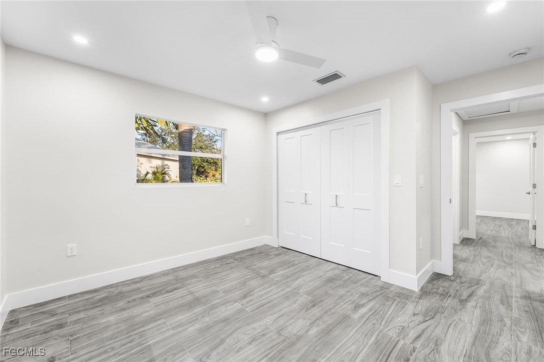 12860 Iona Road Fort Myers, FL 33908 - Photo 33 of 44 an empty room with wooden floor and windows
