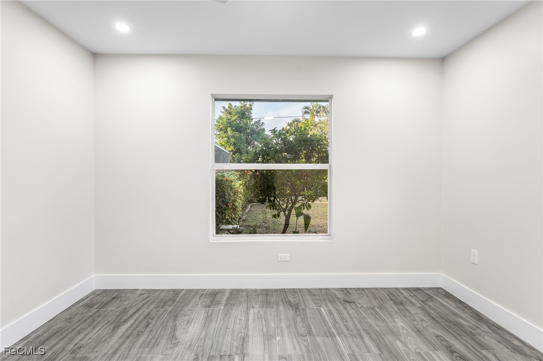 12860 Iona Road Fort Myers, FL 33908 - Photo 34 of 44 an empty room with wooden floor and windows