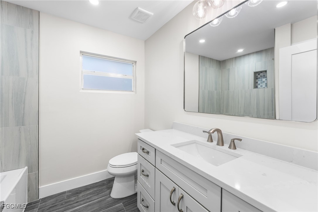 12860 Iona Road Fort Myers, FL 33908 - Photo 35 of 44 a bathroom with a toilet sink and mirror