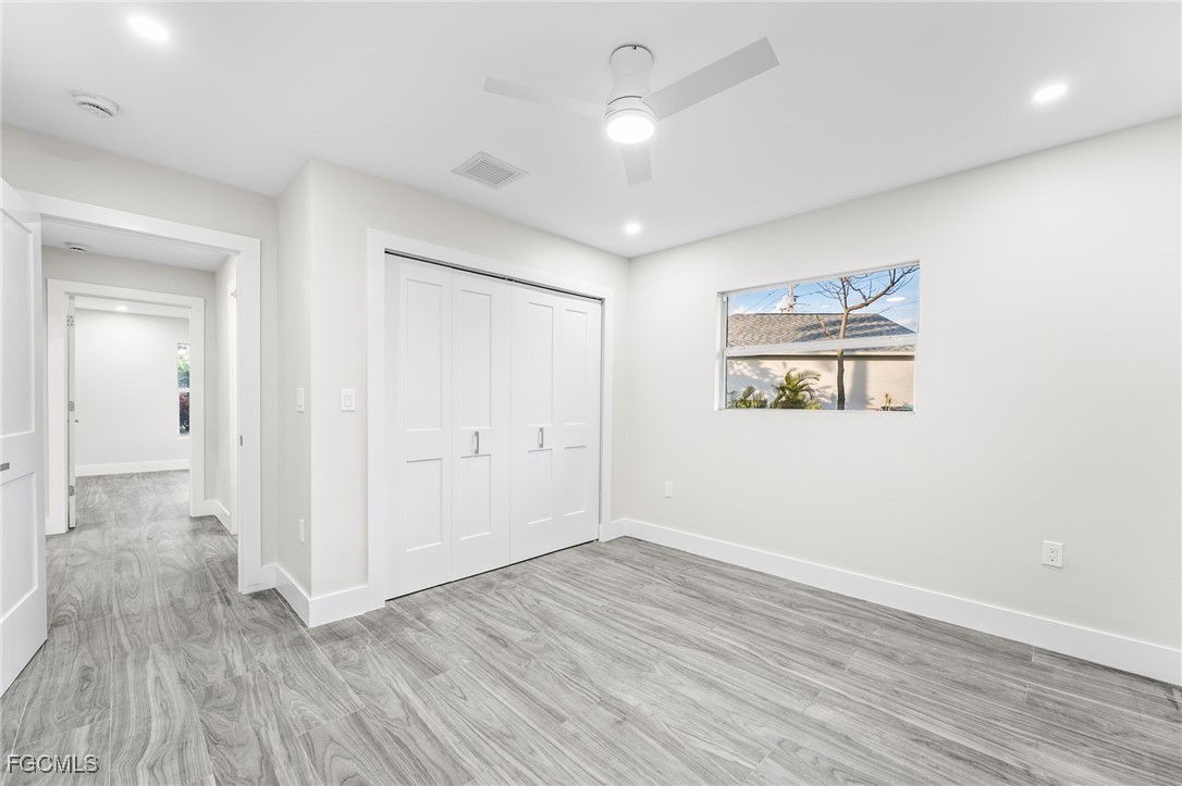 12860 Iona Road Fort Myers, FL 33908 - Photo 37 of 44 an empty room with wooden floor and windows
