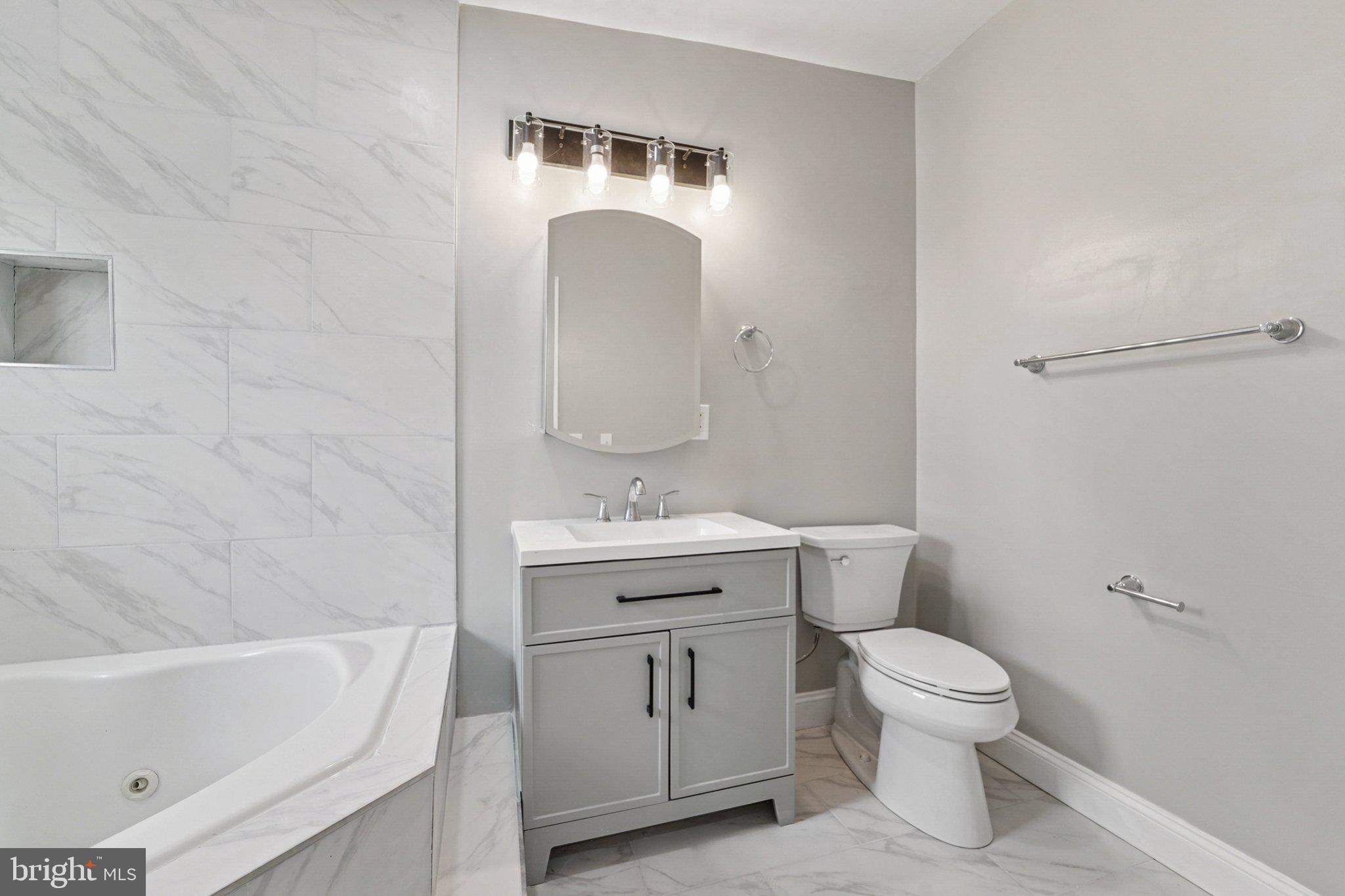 1525 West Pratt Street Baltimore, MD 21223 - Photo 21 of 31 a bathroom with a granite countertop toilet a sink and bathtub