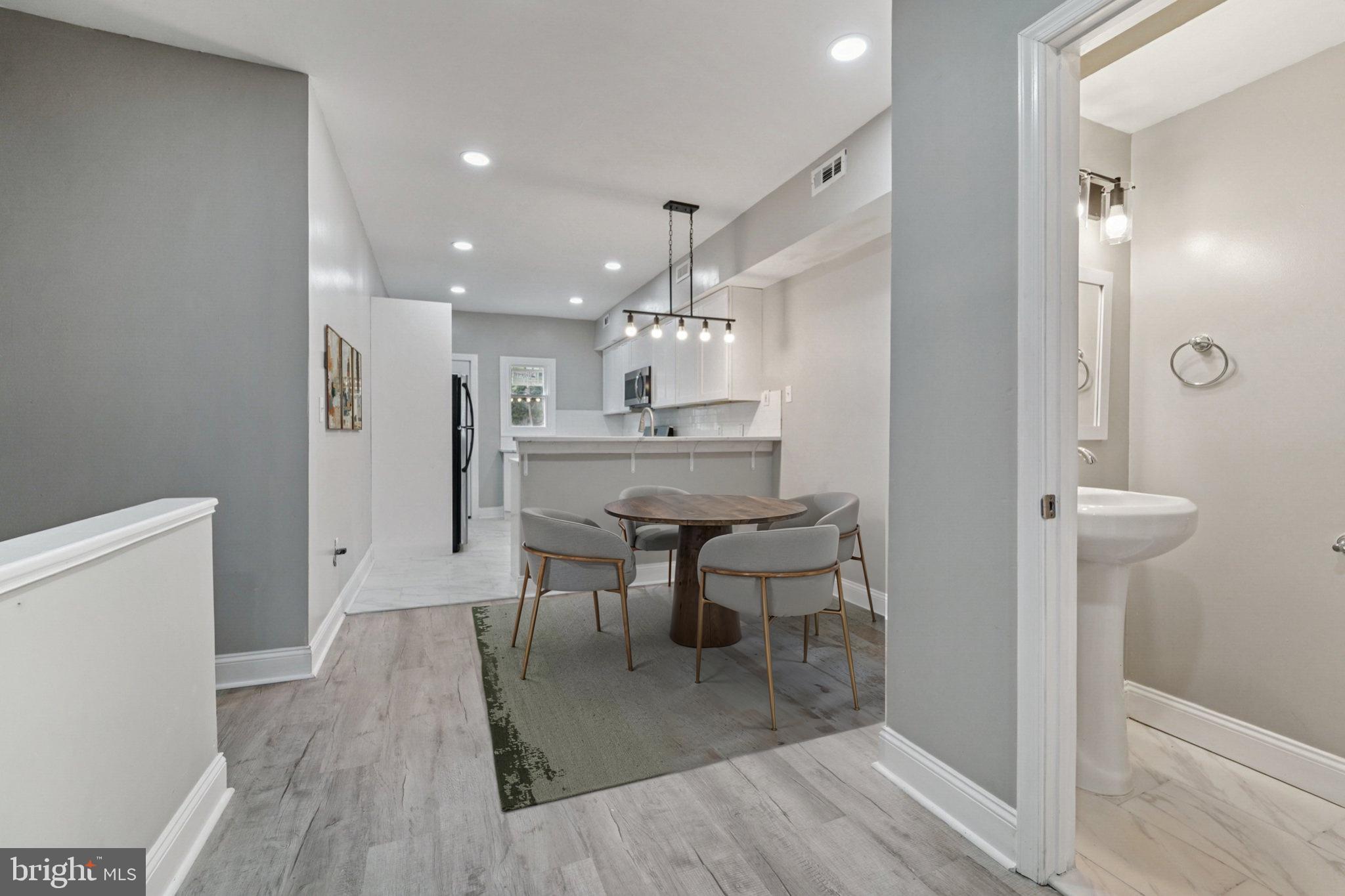 1525 West Pratt Street Baltimore, MD 21223 - Photo 5 of 31 a view of a dining room and livingroom with furniture wooden floor a chandelier