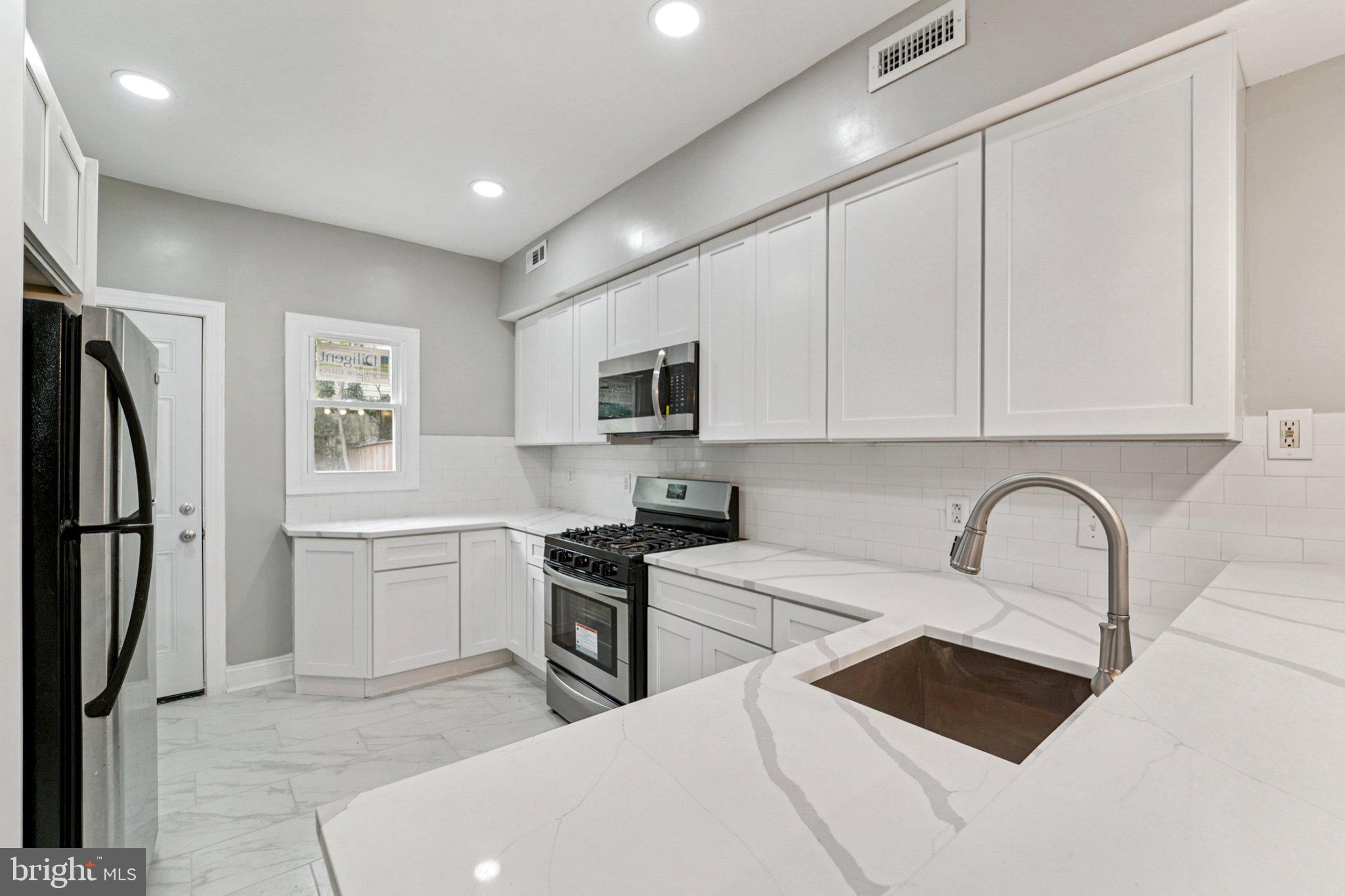 1525 West Pratt Street Baltimore, MD 21223 - Photo 7 of 31 a kitchen with stainless steel appliances granite countertop a refrigerator sink and stove