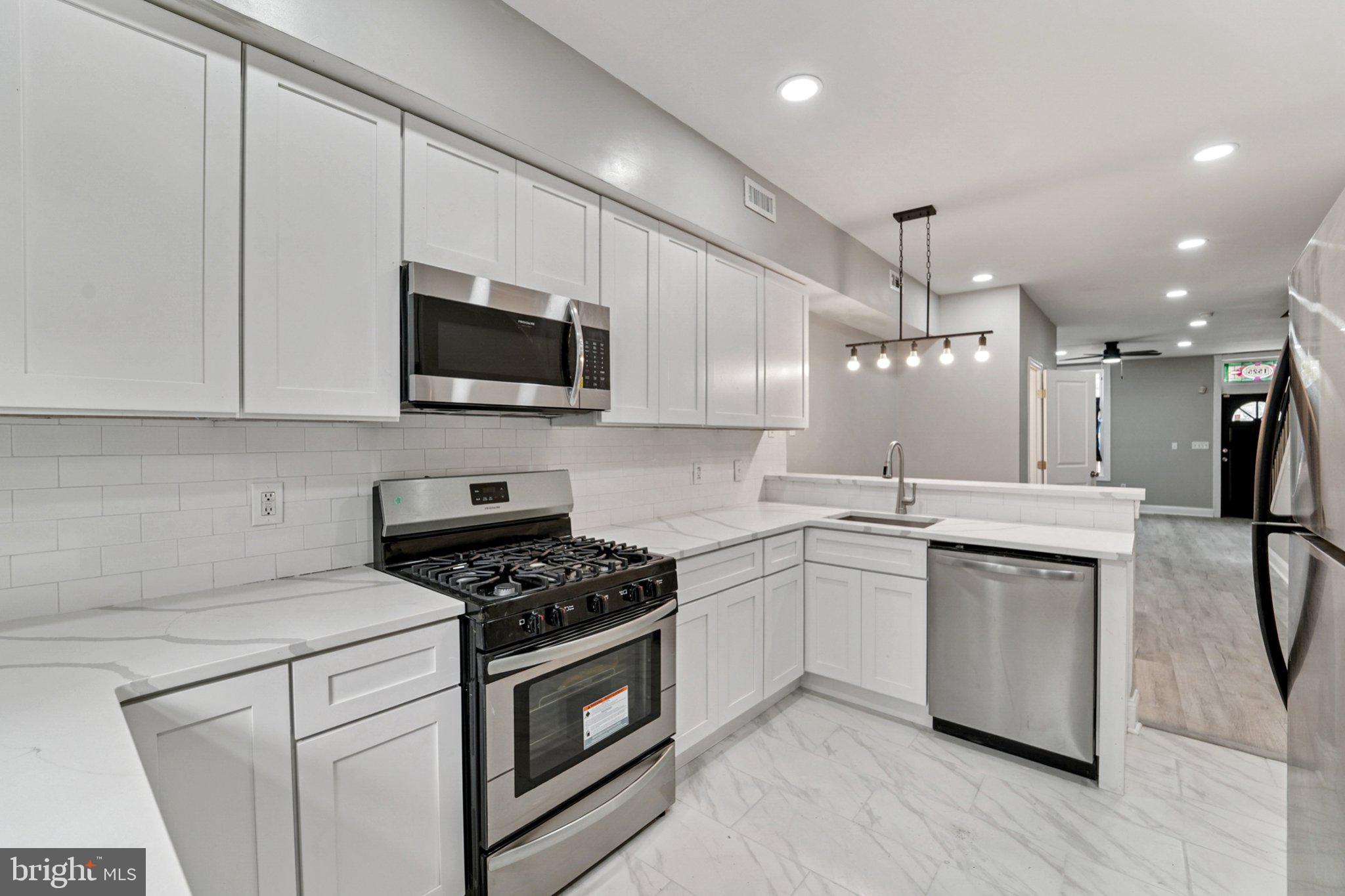 1525 West Pratt Street Baltimore, MD 21223 - Photo 8 of 31 a kitchen with a sink stove and white cabinets