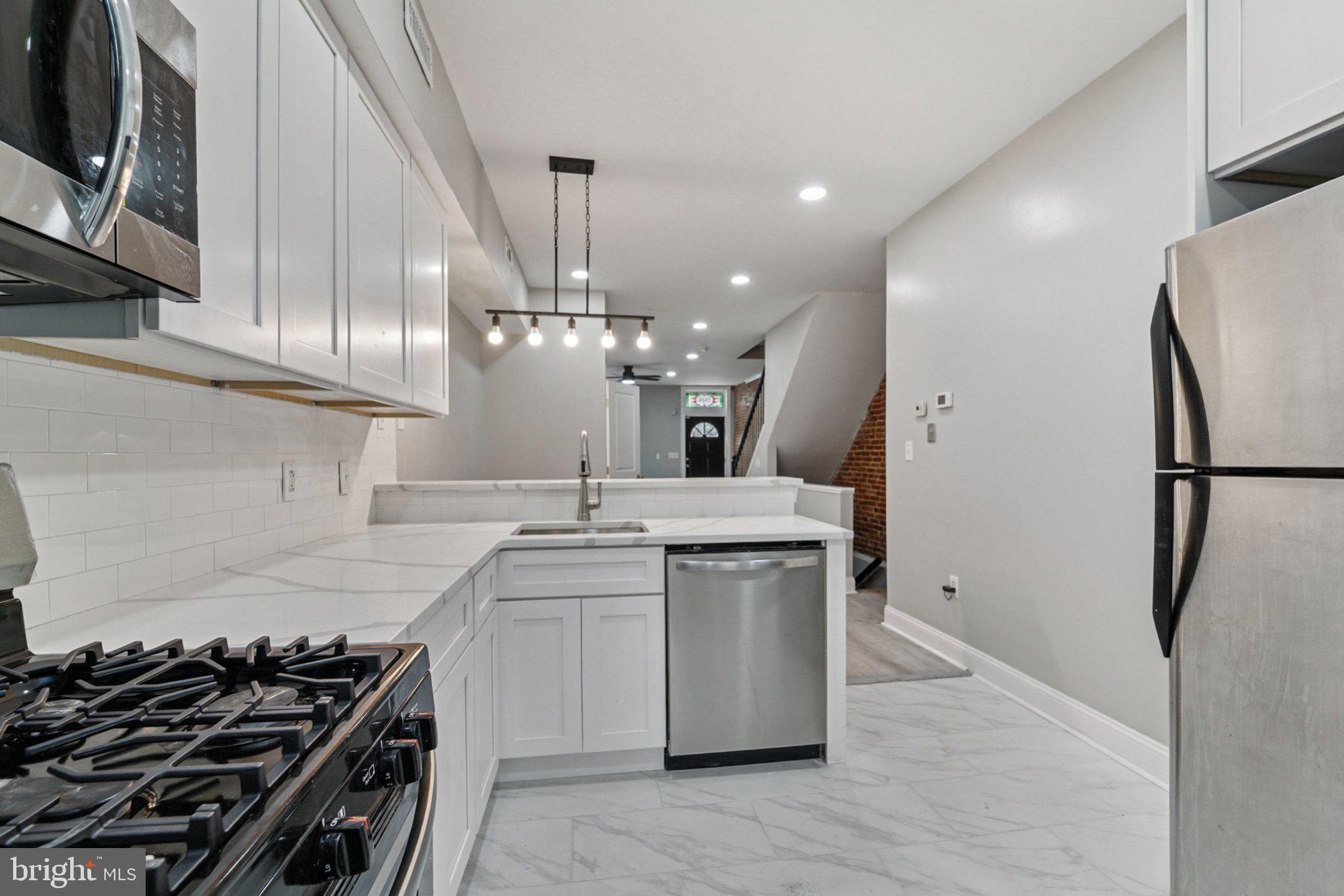 1525 West Pratt Street Baltimore, MD 21223 - Photo 9 of 31 a kitchen with stainless steel appliances a sink stove and refrigerator