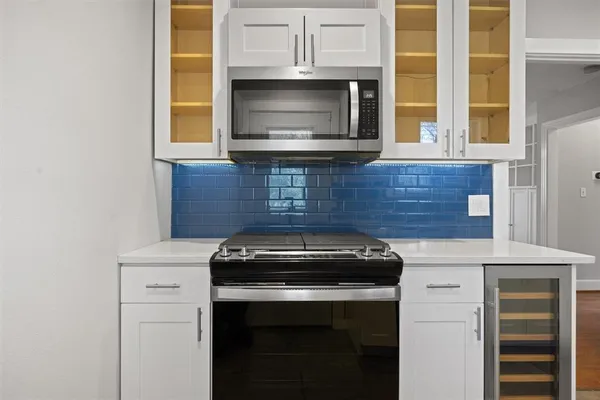 a kitchen with granite countertop white cabinets and black appliances