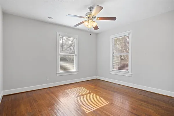 a view of an empty room with a window and wooden floor